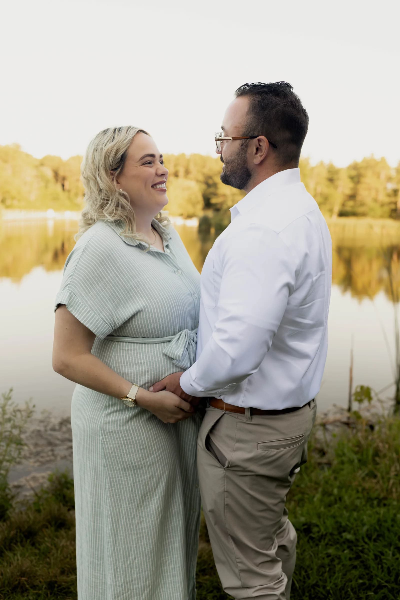 Robbie and Amanda expecting their baby, beside a sunlit pond